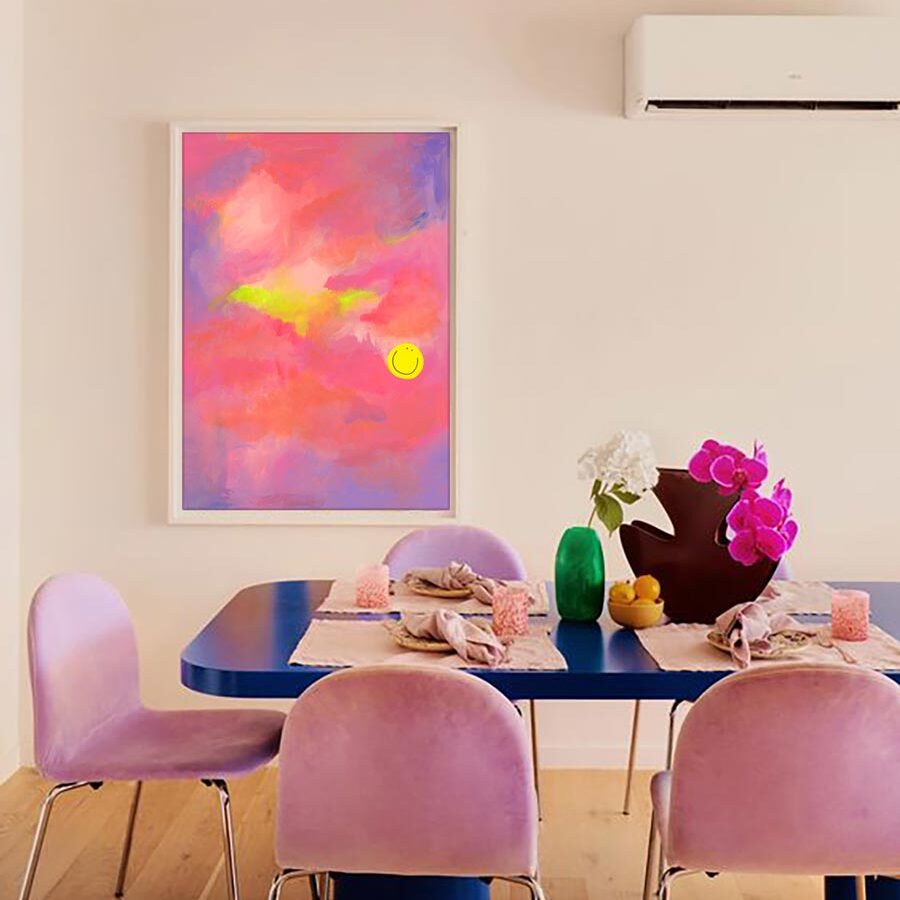 glimmers print which is pink peach and lilac painting with happy face hung above a blue dining table with lilac chairs