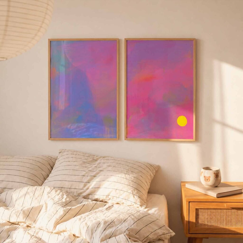 two blue and pink abstract art prints above a bed
