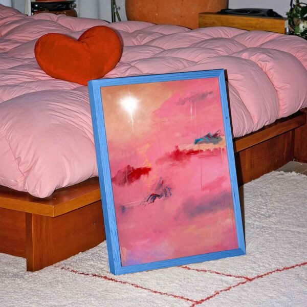 Pink red and blue abstract art propped up against a bed with a pink duvet and heart cushion