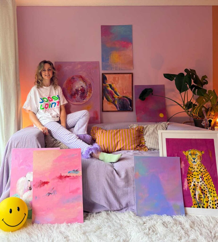 Portrait of Georgie founder of Georgie Web Art surrounded by her fun colourful artwork